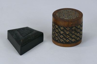 une petite boîte en bois et une petite boîte posées sur une surface blanche
