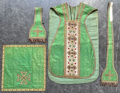 un tissu vert orné d'une croix, à côté d'une brosse à dents et d'autres objets