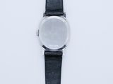 a close up of a watch on a white surface with a black strap