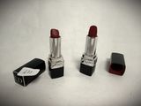 two red lipsticks sitting next to each other on a white surface