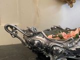 a silver bowl with roses in it sitting on a table