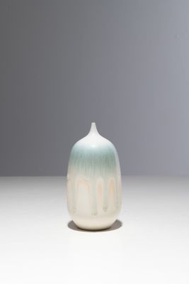 un petit vase blanc et bleu posé sur une table