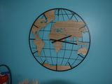 a clock on the wall that has a world map on it