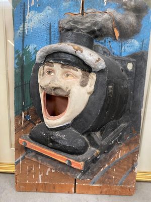 une sculpture en bois représentant une locomotive avec un visage souriant