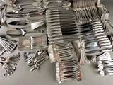 a lot of silver spoons and forks on the table