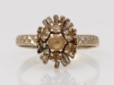 a close up of a gold ring with a brown diamond