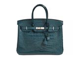a green crocodile skin handbag with a metal clasp