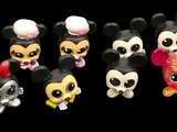 a bunch of mickey and minnie mouse figurines on a black background