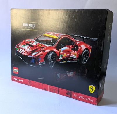 la boîte d'une voiture de sport lego ferrari est ouverte sur une surface blanche