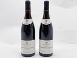 deux bouteilles de vin rouge posées l'une à côté de l'autre sur une surface blanche