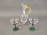 three wine glasses and a pitcher sitting on a table