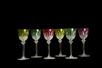 six verres à vin sont alignés sur fond noir