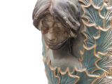 a vase with a statue of a woman on it
