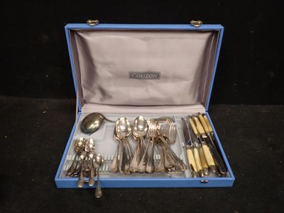 un coffret bleu contenant de l'argenterie, posé sur une surface noire