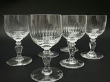 quatre verres à vin vides sont alignés sur une surface noire