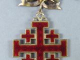 an image of a red and gold cross on a black ribbon