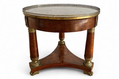 une table ronde avec un plateau en métal et un piètement en bois