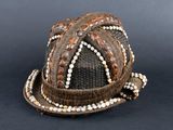 a brown hat with white beads on it on a black surface