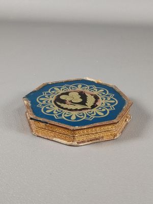une petite boîte bleue et dorée avec une image dessus
