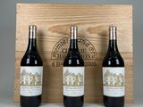 trois bouteilles de vin sont posées devant une caisse en bois