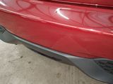 a close up of a red car ' s bumper with a sticker on it