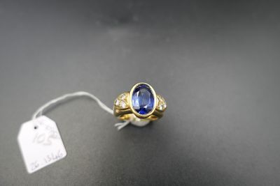 a close up of a ring with a blue stone on a black surface
