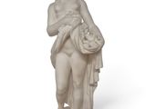 statue d'une femme tenant un panier de fleurs, posée sur un socle