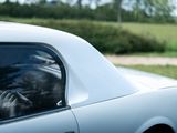 a man sitting in the passenger seat of a car with his head out the window