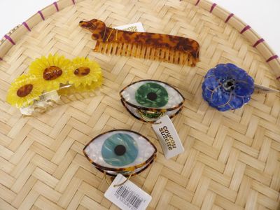 three hair clips and a comb sitting on a tray