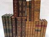 several old books stacked on top of each other on a white surface