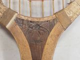 a close up of a tennis racket with a wooden handle