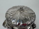 a silver box with a lid on a white table