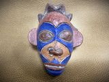 a blue and brown mask on a gold surface