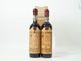 deux bouteilles de vin posées l'une à côté de l'autre sur une surface blanche