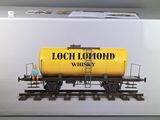 a box with a yellow tank sitting on a train track