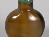 a brown glass bottle with a green lid