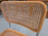 a wicker chair with a metal frame and a wooden seat