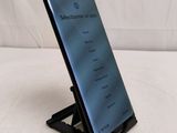a close up of a cell phone on a stand on a white surface