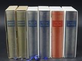 quatre livres sont alignés les uns à côté des autres sur une surface noire