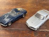 deux petites voitures posées sur une table en bois