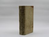 an old book sitting on top of a table on a white surface