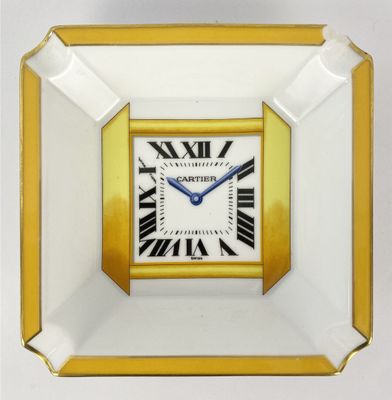 an image of a gold and white square clock with roman numerals