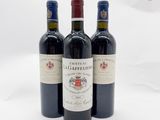 trois bouteilles de vin rouge posées l'une à côté de l'autre sur une surface blanche