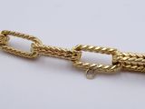 a close up of a gold chain on a white surface