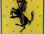 une horloge jaune avec un cheval noir sur le cadran