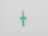 an emerald cross pendant on a white background