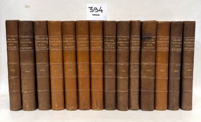 six old books are lined up in a row on a white surface