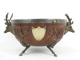 an image of a metal bowl with deer heads and a shield on it