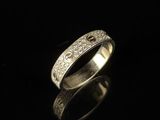gros plan d'une bague en argent sur une surface noire
