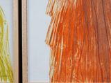 two framed pictures of different colored dresses on the wall